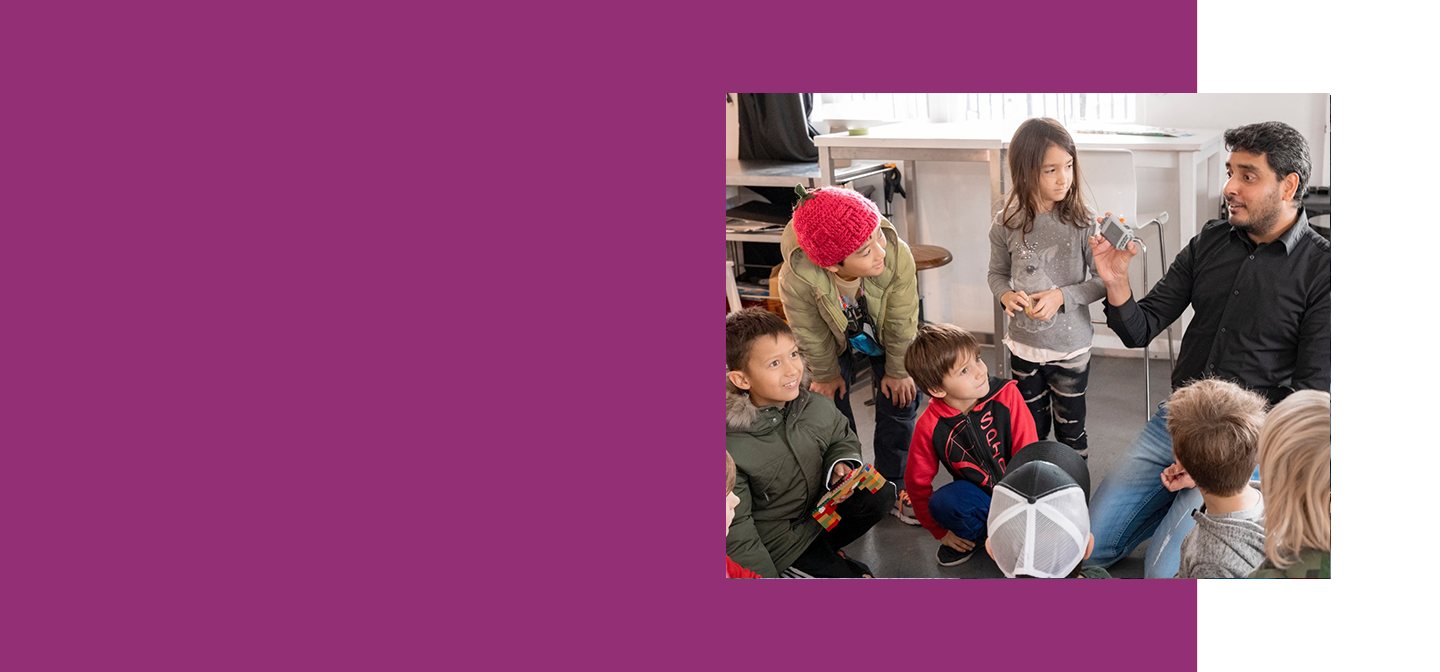 Facilitator showing a motorized LEGO component to a group of children